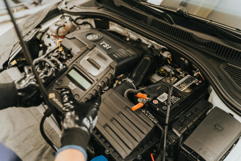 pexels-photo-13065689-13065689 Close-up view of a mechanic diagnosing a Volkswagen engine with specialized equipment.