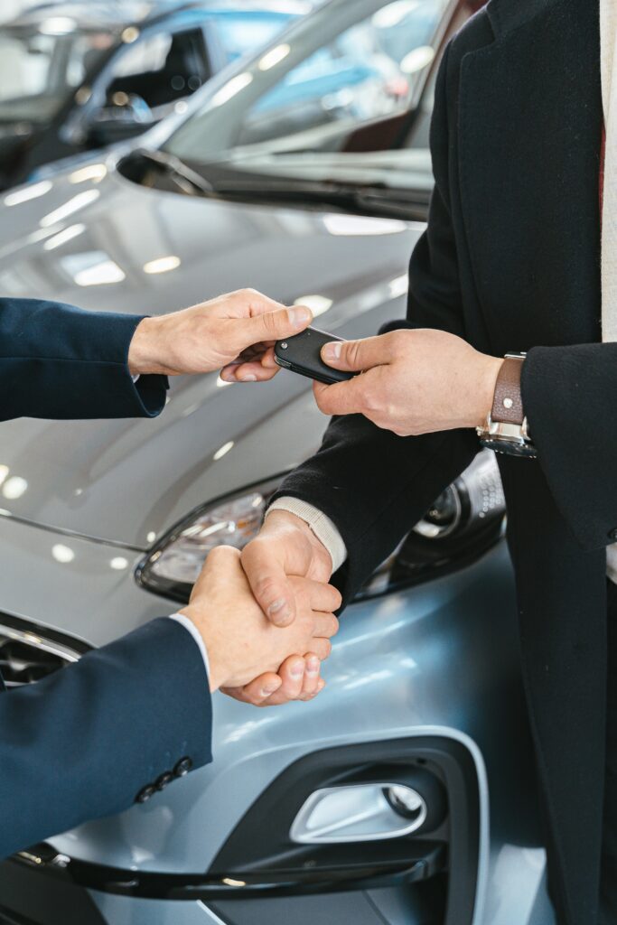 pexels-photo-7144212-7144212 Close-up of a business handshake as car keys are handed over, symbolizing a new car purchase.